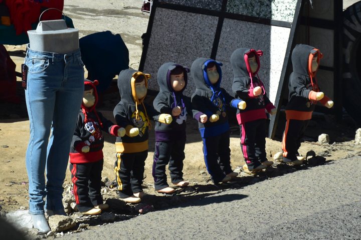 Sechs Kinderschaufensterpuppen und eine Jeans am Strassenrand