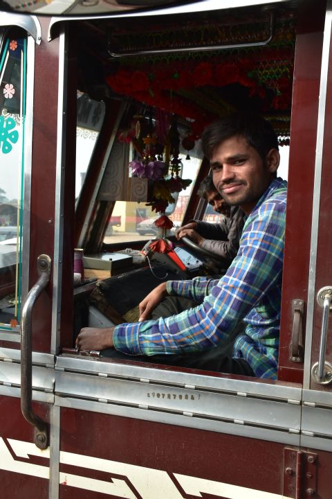 Eine Lastwagenbesatzung steht mit ihrem Tata auf dem Weg von Agra nach Fatehpur Sikri neben uns an der Zahlstelle an