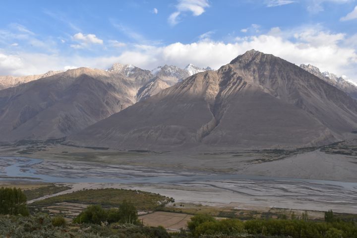 Der afghanische Wakhan Korridor reicht vom Panj bis zu den schneebedeckten Gipfeln. Dahinter liegt Pakistan.