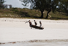 Fischer ziehen einen Einbaum auf den Strand
