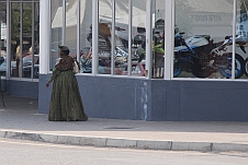 Tradition und Moderne in Windhoek: Hererofrau vor Motorradverkaufsvitrine