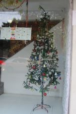 Dünnes aber üppig geschmücktes Weihnachtsbäumchen in einem Schaufenster