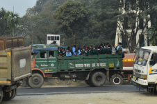 Kinder in Schuluniform auf der Ladebrücke eines Lastwagens unterwegs zur Schule