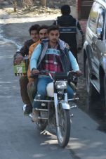 Drei junge Männer auf einem Motorrad