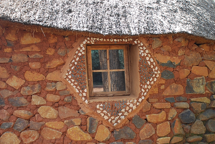 Liebevolle Fensterverzierung bei einer H&uuml;tte in der Malealea Lodge