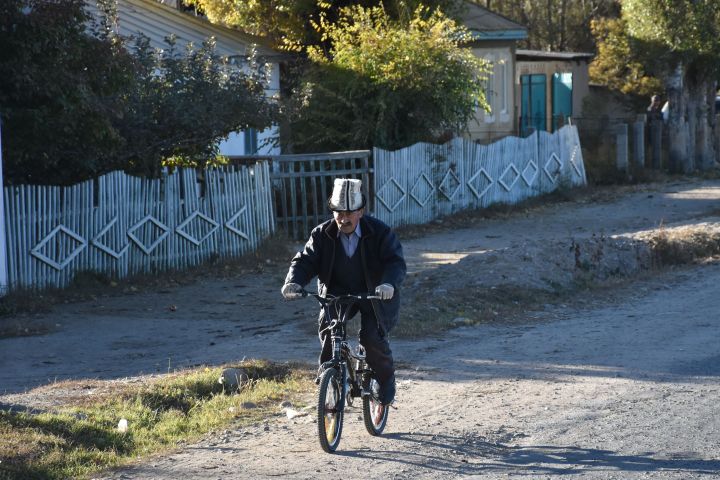 &Auml;lterer Kirgise unterwegs mit einem Freestyle Bike in Kara-Koo am Issyk-K&ouml;l
